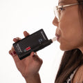 A woman blowing into Andatech AlcoSense Elite 3 Personal Breathalyser