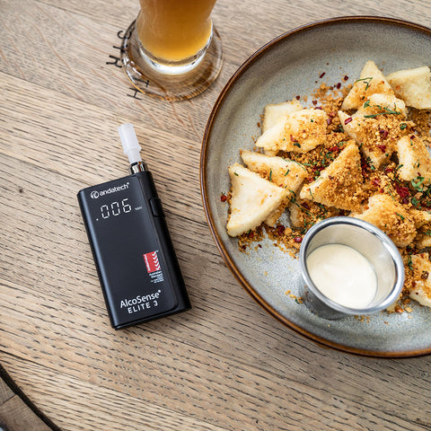 Andatech AlcoSense Elite 3 Personal Breathalyser on table with beer and food