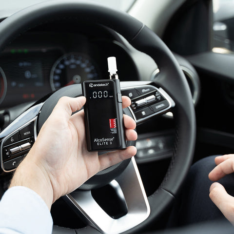 A man holding Andatech AlcoSense Elite 3 Personal Breathalyser in the car