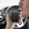 A man blowing into Andatech AlcoSense Stealth Personal Breathalyser