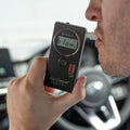 A man blowing into the Andatech AlcoSense Zenith+ Personal Breathalyser